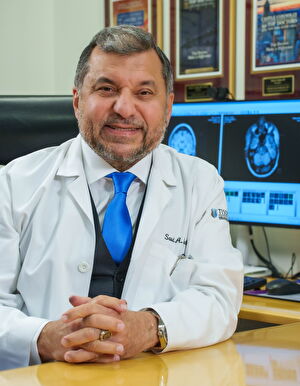 Dr. Sadiq sits at his desk
